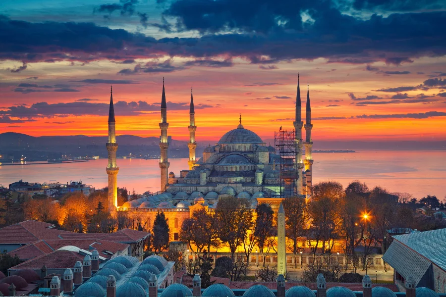 The historic Blue Mosque with its six minarets illuminated during a breathtaking sunrise in Istanbul, Turkey.