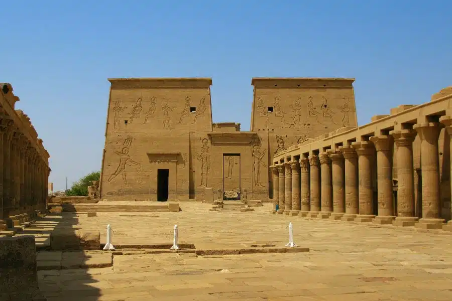 Philae Temple complex in Aswan, Egypt, featuring ancient columns, intricate hieroglyphs, and a serene Nile River backdrop.